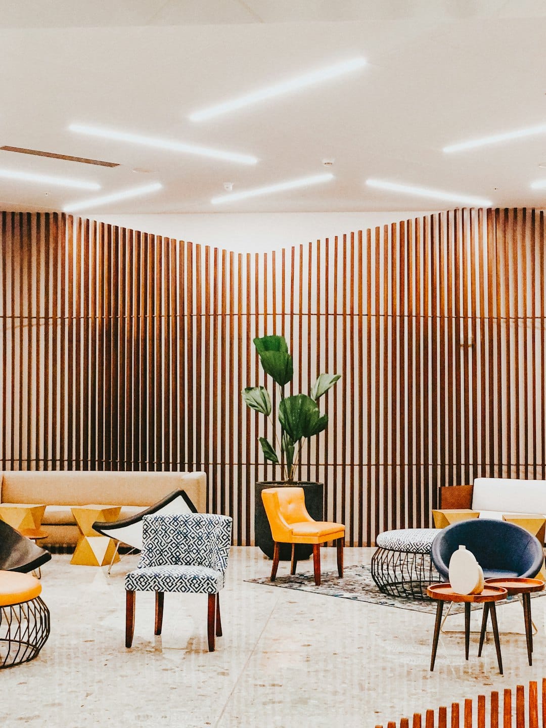 Moderne Hotellobby mit beigen Sofas und bunten Sesseln.